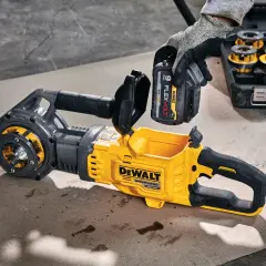 Ręka w rękawicy wkłada baterię do żółto-czarnego narzędzia DeWalt. Solidna konstrukcja i gwarancja DeWalt zapewniają niezawodność.