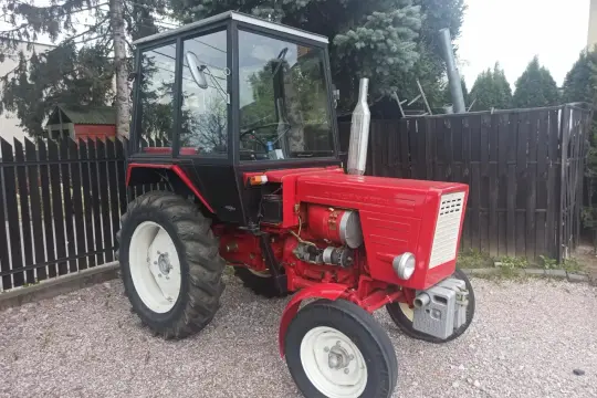 Czerwony traktor Władimirec T25 z kabiną. Wady i zalety tego modelu są szeroko dyskutowane przez rolników.