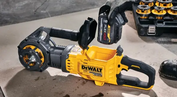 Ręka w rękawicy wkłada baterię do żółto-czarnego narzędzia DeWalt. Solidna konstrukcja i gwarancja DeWalt zapewniają niezawodność.