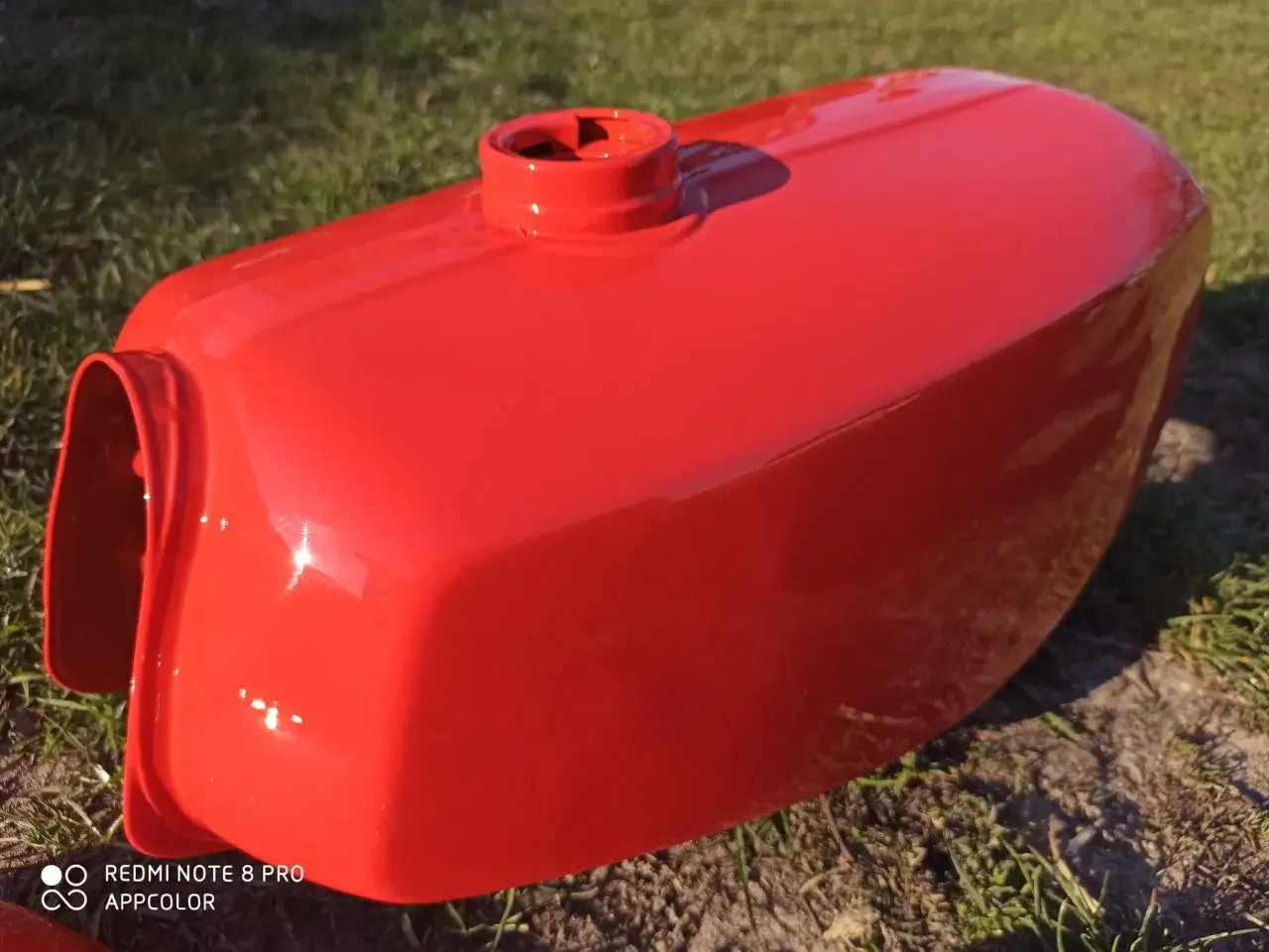 Błyszczący bak motocyklowy w kolorze czerwień meksykańska RAL, gotowy na nowe przygody.